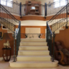 départ escalier demi rond dans une entrée avec fer forgé