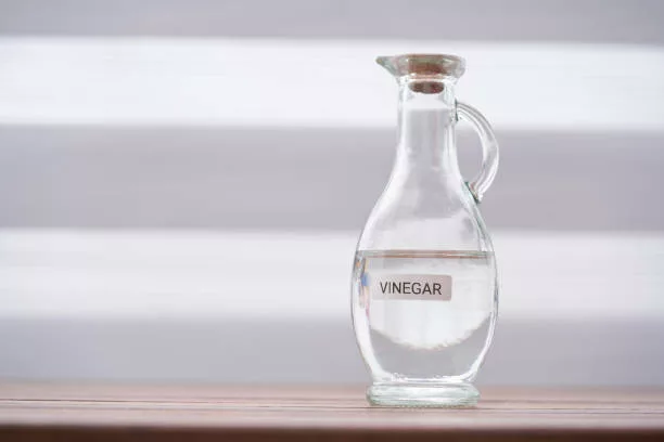 Vinaigre blanc sur plateau de table en bois