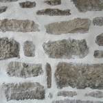 Mur en pierres reconstituées jointoyées au mortier blanc, texture rustique