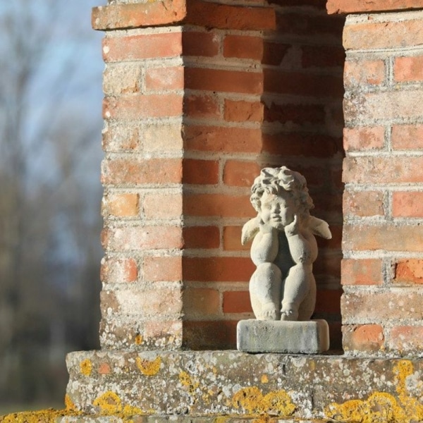 Putto pensif sous une arche en brique