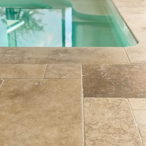 carrelage travertin choix naturel au bord d'une piscine