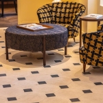 Détail dallage à cabochons Poillé en pierre reconstituée avec cabochons noirs dans un salon élégant