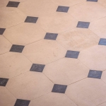 Détail du dallage à cabochons Poillé en pierre reconstituée beige avec cabochons noirs et finition légèrement texturée