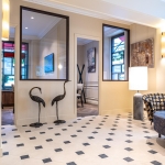 Dallage à cabochons Poillé en pierre reconstituée avec cabochons noirs posé en motif octogonal dans une entrée élégante