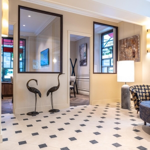 Dallage à cabochons Poillé en pierre reconstituée avec cabochons noirs posé en motif octogonal dans une entrée élégante