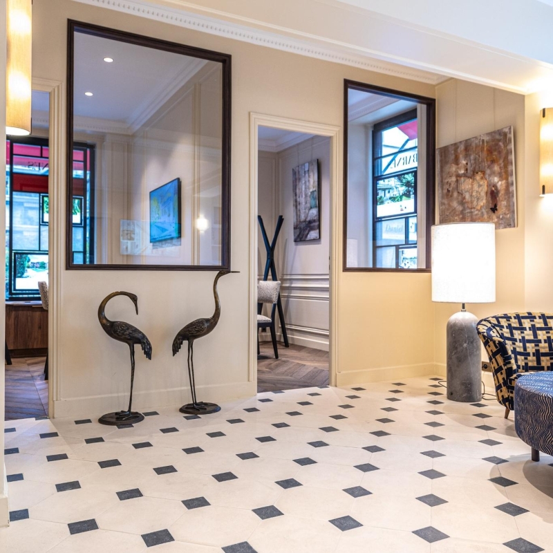 Dallage à cabochons Poillé en pierre reconstituée avec cabochons noirs posé en motif octogonal dans une entrée élégante