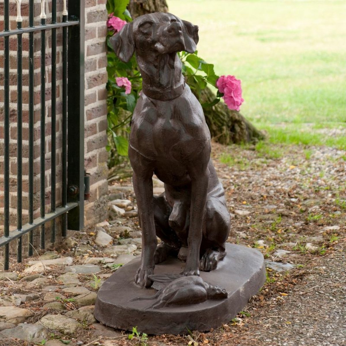 statue de chien d'arrêt devant un portail