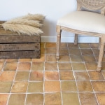 Tomette carrée claire posée avec chaise et cage en bois
