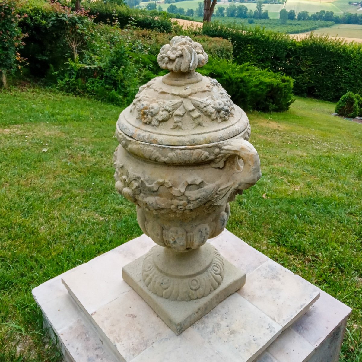 urne anses sur socle en pierre dans un jardin