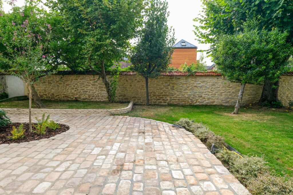 Extérieur avec de la verdure ainsi qu'une grande et large allée de pavés Chantilly clairs