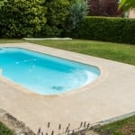 dallage terrastinus autour d'une piscine dans un grand jardin