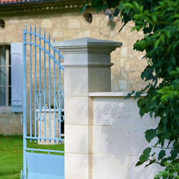 un pilier valançay sur lequel est fixé un portail bleu