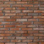 zoom sur un mur recouvert de pierre de parement brique naturelle rouge non rectifiée