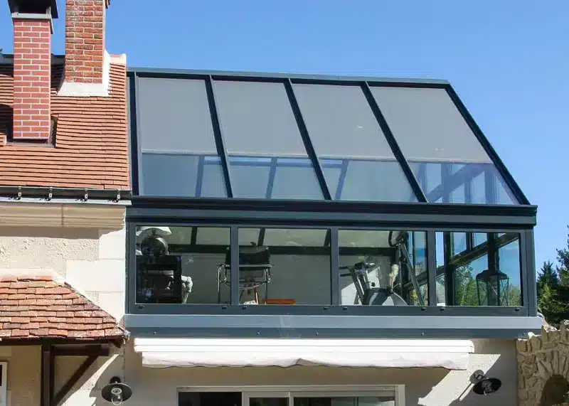veranda pergola aluminium avec grandes baies vitrées vue de l'extérieur
