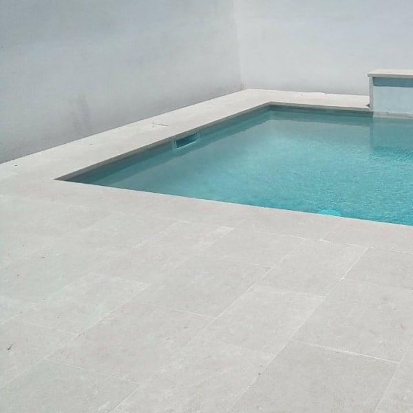 sol pierre calcaire claire autour d'une piscine