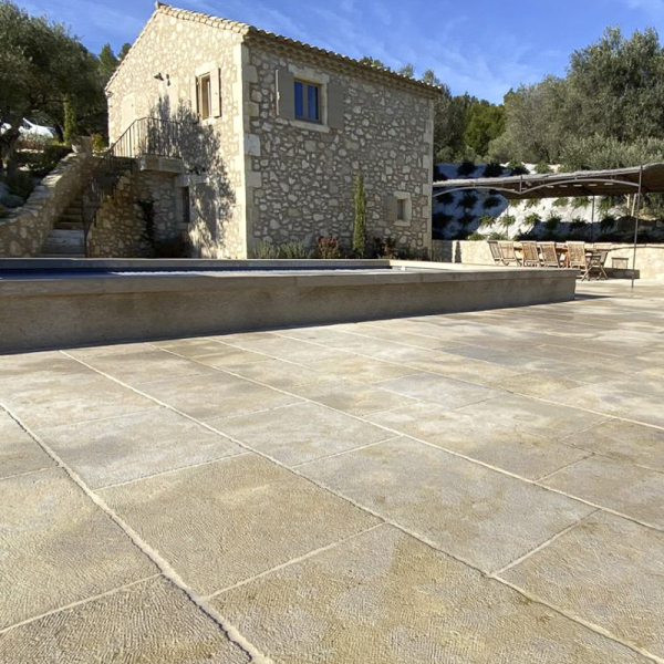 Dallage pierre naturelle beige Dallage pierre naturelle beige Castel dans un quartier résidentiel