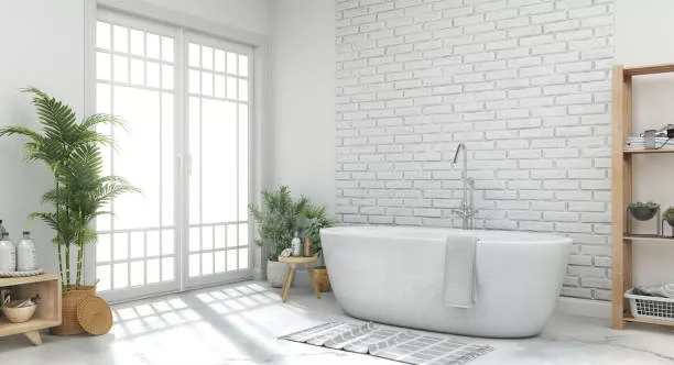 Salle de bain aux couleurs blanches avec une baignoire et un parement mural en brique.