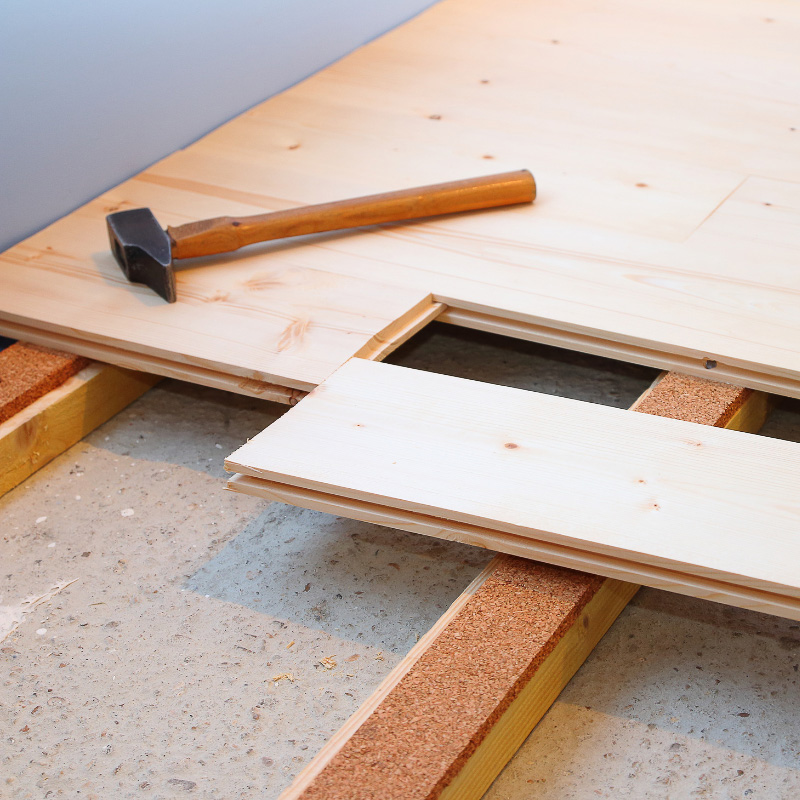 Guide pose de parquet massif sur carrelage avec marteau et lambourdes