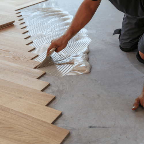 application de la colle sur dalle beton pour pose parquet massif