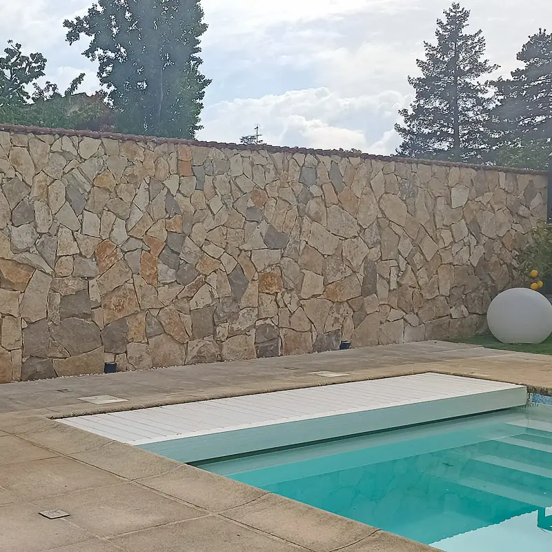 pierre de parement brune sur un mur derrière la piscine