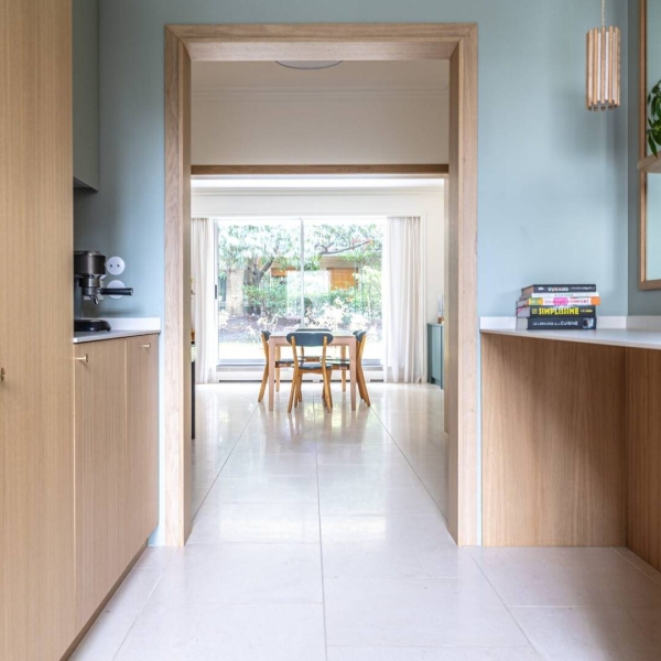 Dallage en pierre de Combe Brune beige clair grand format dans un espace de circulation entre cuisine et salle à manger