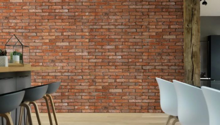 Mur de brique dans une salle à manger avec des chaises blanches et grises